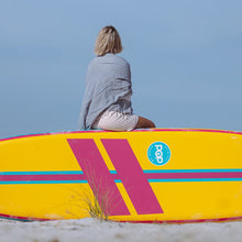 Load image into Gallery viewer, A woman on top of POP Board Co 11&#39;0 Yacht Hopper Turq/Pink/Ylw Stand Up Paddle Board
