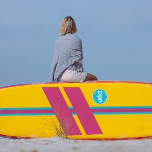 A woman on top of POP Board Co 11'0 Yacht Hopper Turq/Pink/Ylw Stand Up Paddle Board