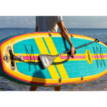Load image into Gallery viewer, A person carrying the POP Board Co 11&#39;0 Yacht Hopper Turq/Pink/Ylw Stand Up Paddle Board
