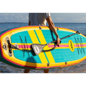 A person carrying the POP Board Co 11'0 Yacht Hopper Turq/Pink/Ylw Stand Up Paddle Board
