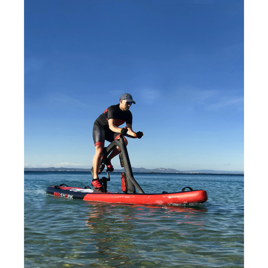 Red Shark Bike Surf Fitness Water Bike With A Man Riding On It