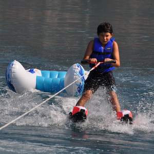 A boy skiing using Rave Shredder Combo Water Skis