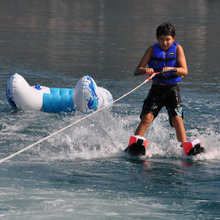 Load image into Gallery viewer, A boy skiing using Rave Shredder Combo Water Skis
