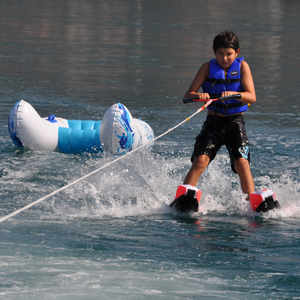 A boy skiing using Rave Shredder Combo Water Skis